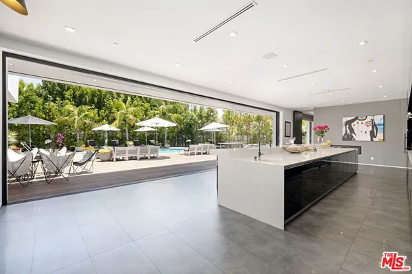 a large white kitchen with a large window and sink