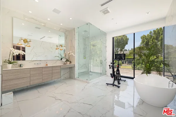 a bathroom with a large tub shower and sink