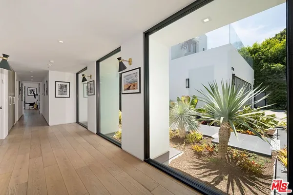a bedroom with a bed painting on wall and a large window