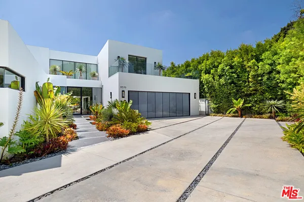 a front view of a house with a yard and a garden
