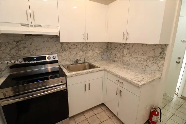 a kitchen with granite countertop white cabinets and white appliances