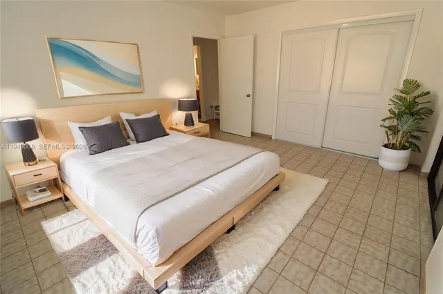 a bedroom with a bed and a potted plant