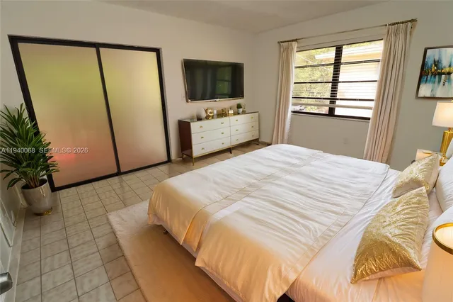 a bedroom with a bed and a television