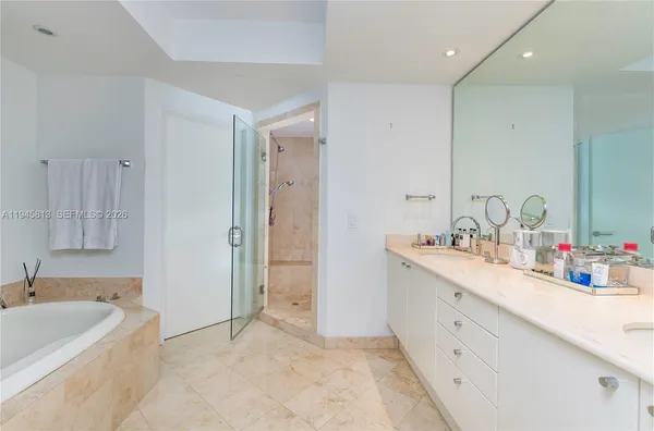 a bathroom with a tub sink and mirror