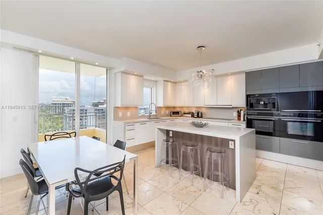 a kitchen with a stove a sink a kitchen island with chairs and wooden cabinets
