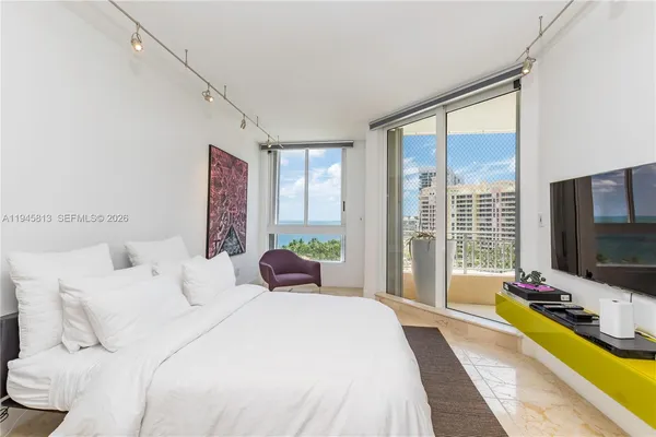 a bedroom with bed tv and window