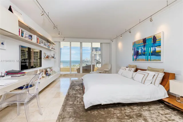 a spacious bedroom with a bed couch and a large window