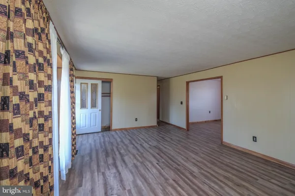 a view of a kitchen with wooden floor electronic appliances and windows