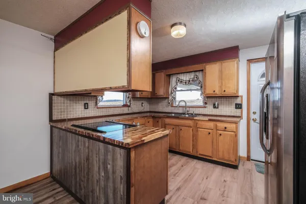 a kitchen with stainless steel appliances granite countertop a sink and dishwasher with wooden cabinets