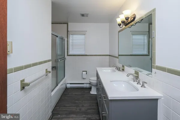 a bathroom with a granite countertop sink a toilet and shower