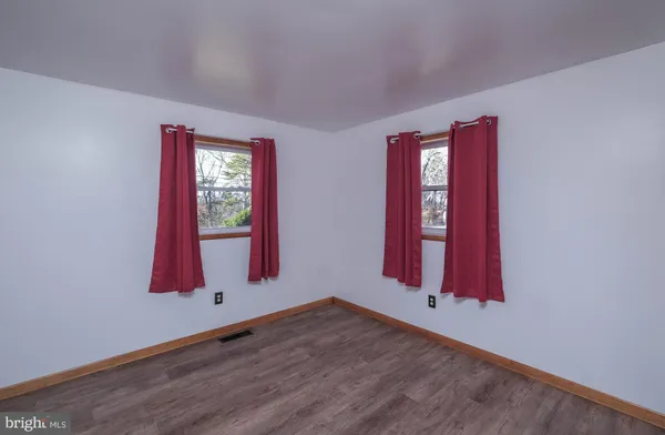 a view of a room with wooden floor and windows
