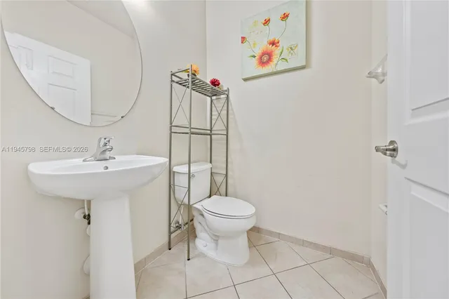 a bathroom with a sink toilet and a mirror