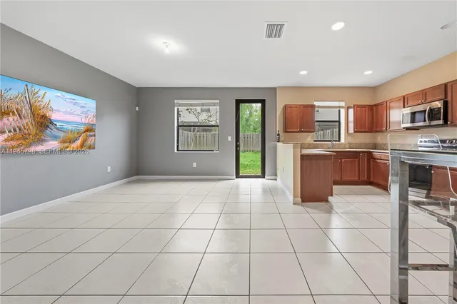 a open kitchen with stainless steel appliances granite countertop a stove top oven a sink dishwasher and a refrigerator with wooden floor