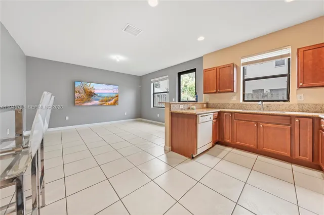 a large kitchen with stainless steel appliances granite countertop a stove sink and cabinets