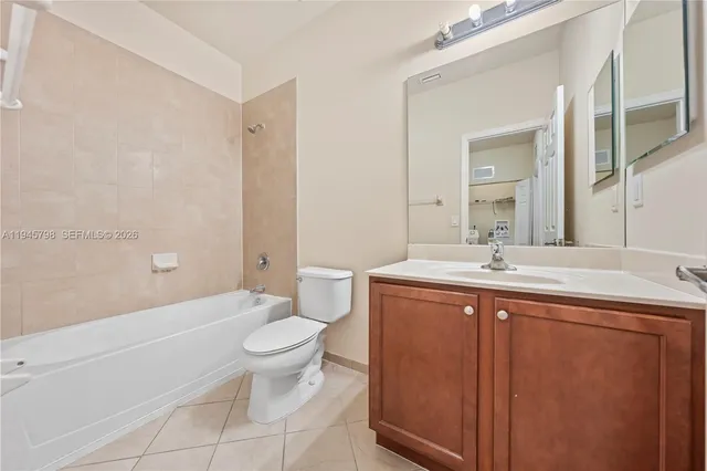a spacious bathroom with a sink a toilet a large mirror and shower