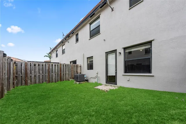 a view of backyard with potted plants and wooden fence