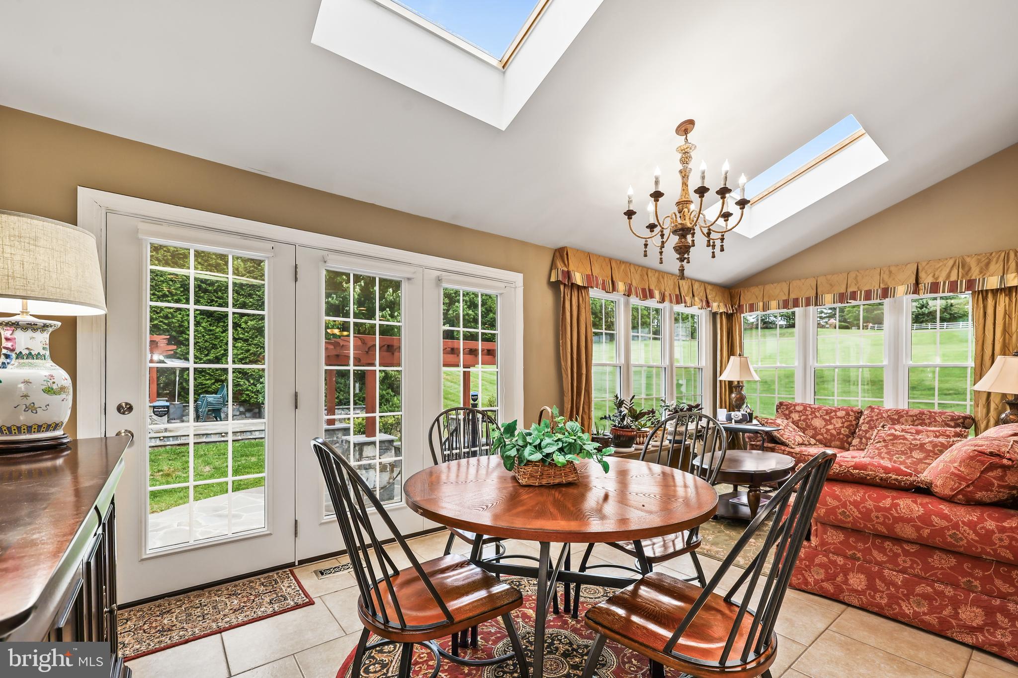 40890 Beechnut Road Leesburg, VA 20175 - Photo 21 of 65 a view of a dining room with furniture a chandelier and large windows