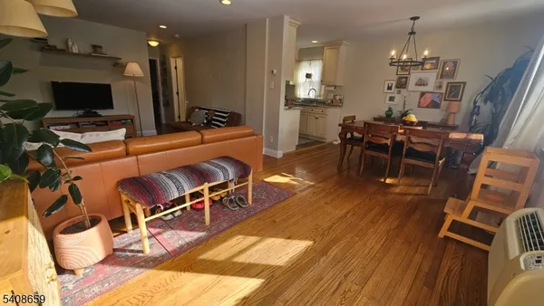 a living room with furniture a flat screen tv and kitchen view