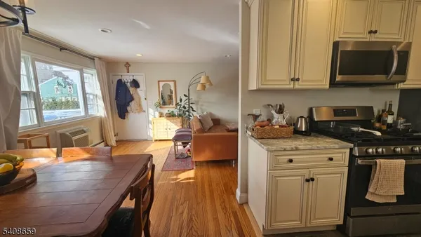 a kitchen with stainless steel appliances granite countertop a stove a sink dishwasher and microwave with wooden floor