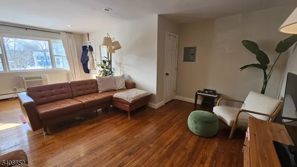 a living room with furniture a window and wooden floor
