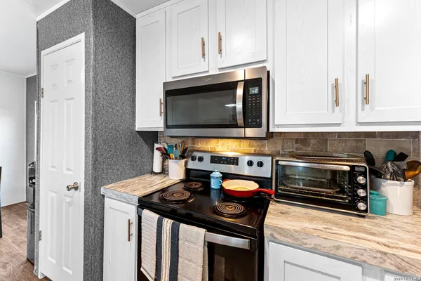 a kitchen with stainless steel appliances a stove a microwave and cabinets