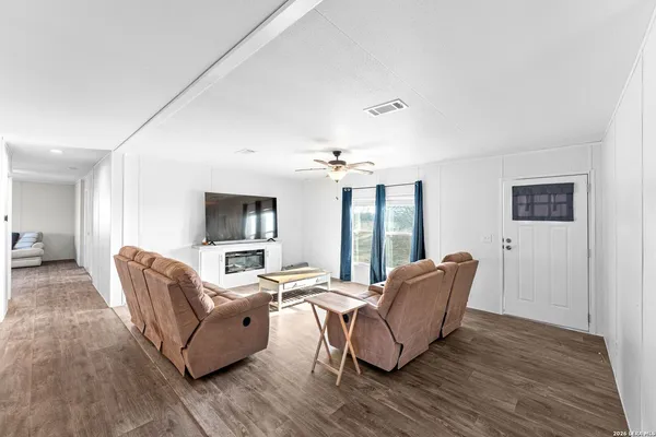 a living room with furniture and a wooden floor