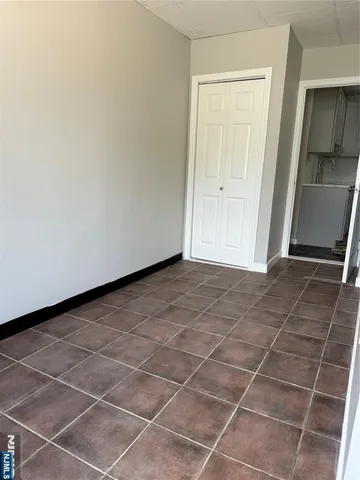 a view of an empty room with stairs and a window