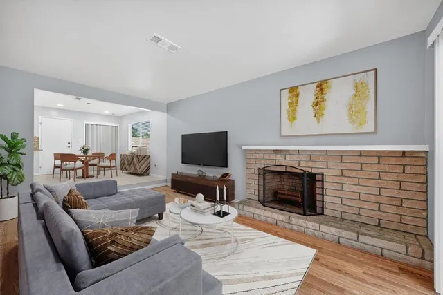 a living room with furniture a fireplace and a flat screen tv