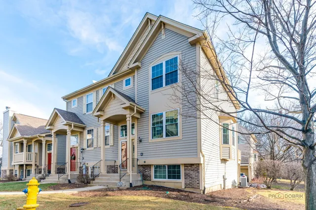 a view of a white house with a large windows and a tree