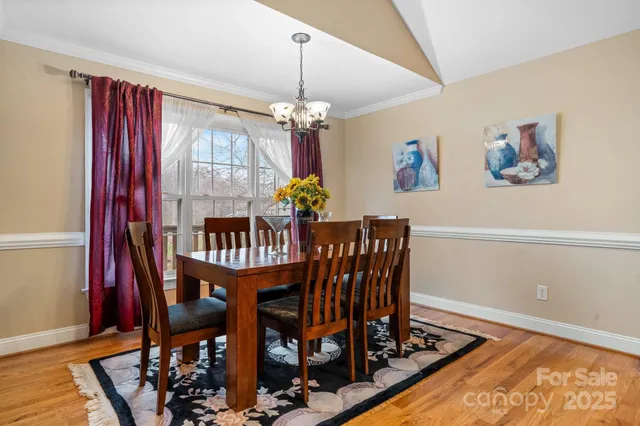 a dining room with furniture a chandelier and wooden floor