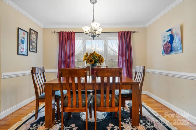 a view of a dining room with furniture wooden floor and chandelier