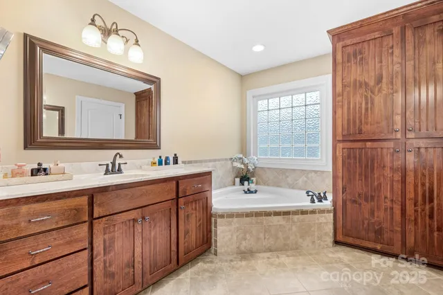 a bathroom with a tub a sink and mirror