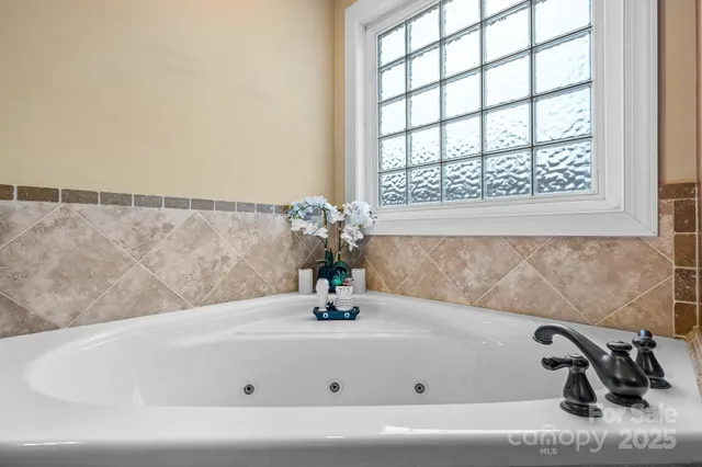 a white bath tub sitting in a bathroom next to a window