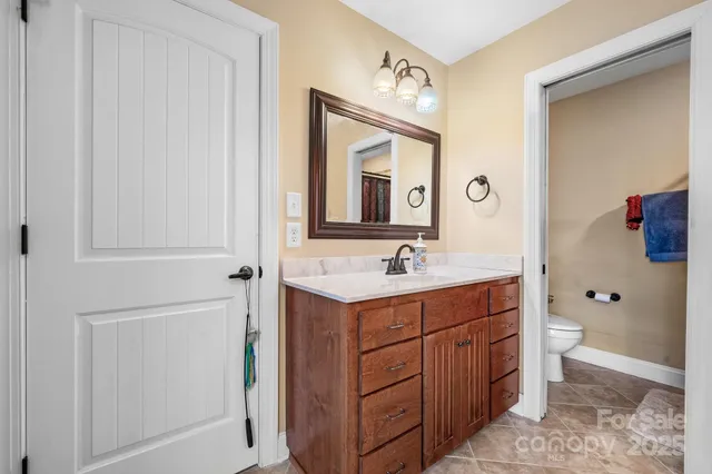 a bathroom with a sink vanity mirror and toilet