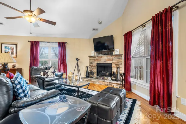 a living room with furniture a fireplace and a flat screen tv