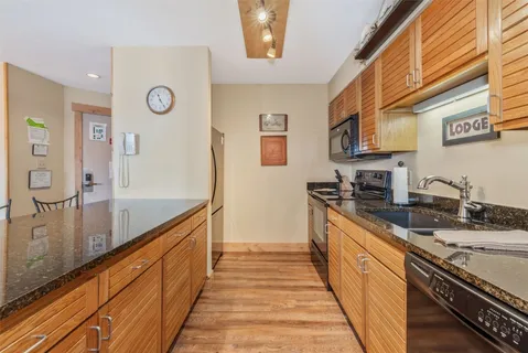 a large kitchen with stainless steel appliances granite countertop a sink and cabinets