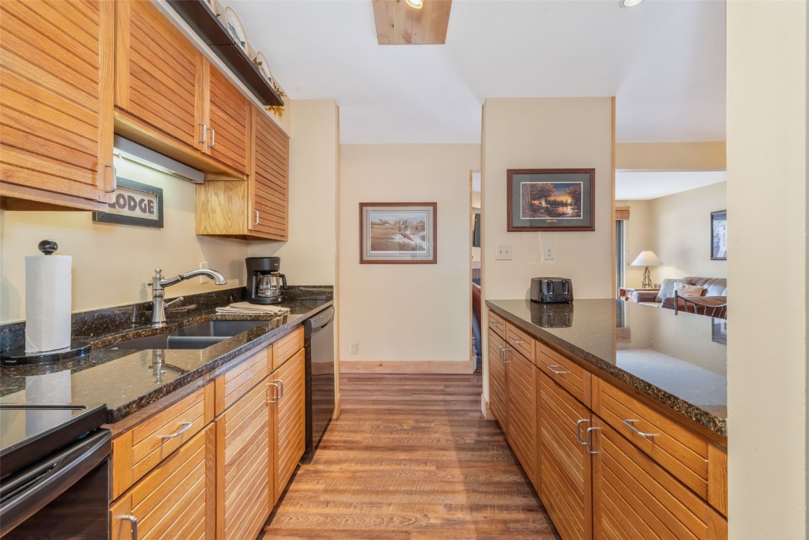 2015 Walton Creek Road, Unit 113 Steamboat Springs, CO 80487 - Photo 17 of 33 a large kitchen with stainless steel appliances granite countertop lots of counter top space and wooden floor