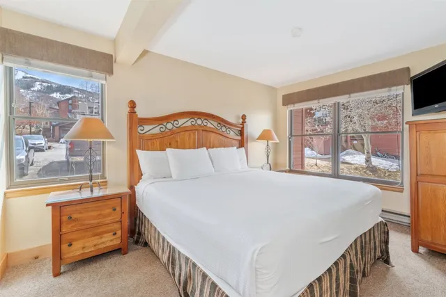 a bedroom with a bed and a flat tv screen on dresser