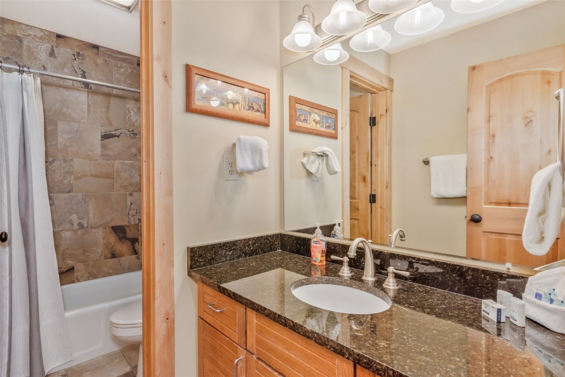 2015 Walton Creek Road, Unit 113 Steamboat Springs, CO 80487 - Photo 23 of 33 a bathroom with a granite countertop sink mirror and shower