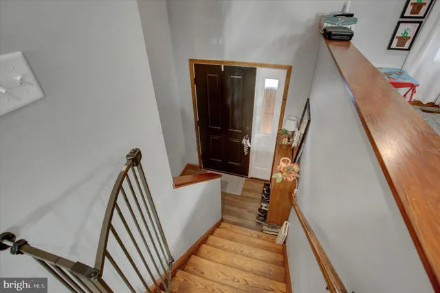 a view of a hallway with wooden floor and stairs