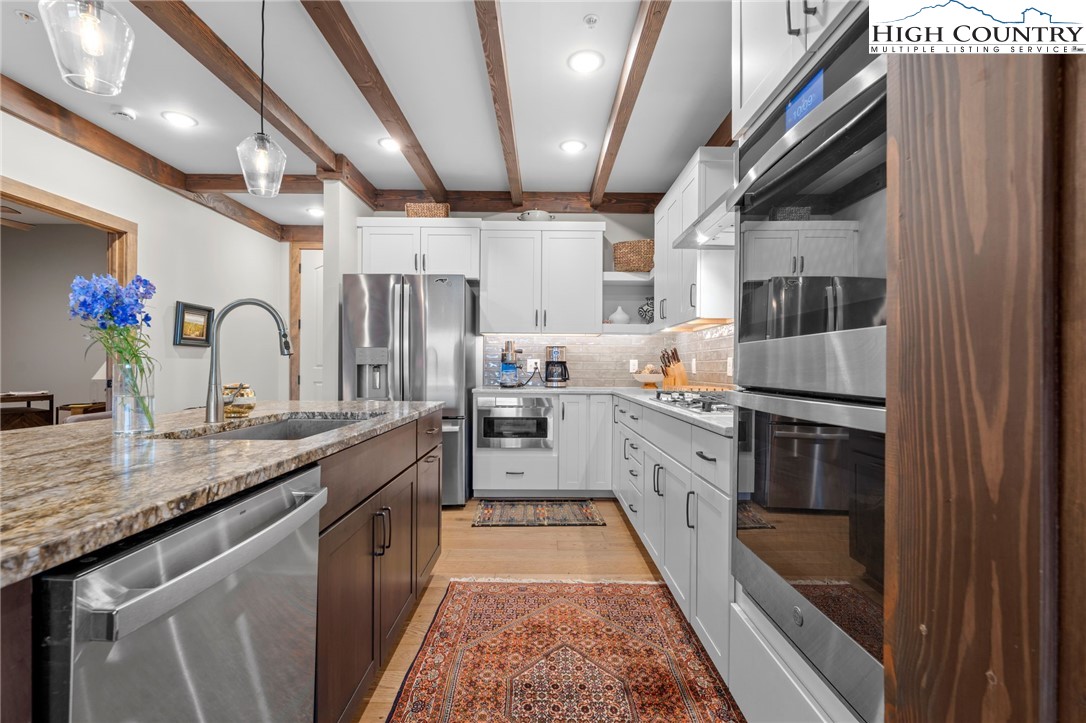 396 Summit View Parkway, Unit S1221 Boone, NC 28607 - Photo 7 of 37 a kitchen with granite countertop stainless steel appliances a sink stove top oven and cabinets