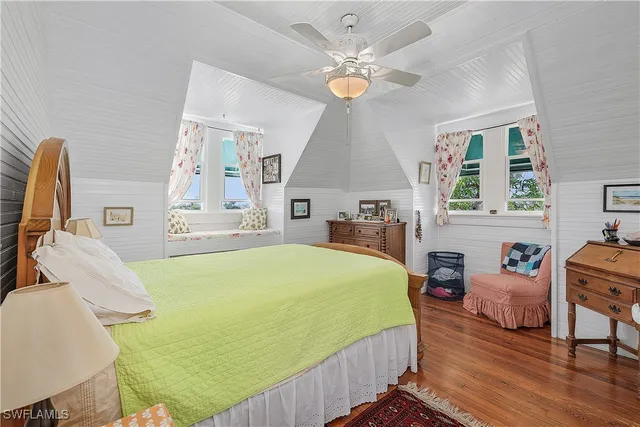 a bedroom with a bed wooden floor and window