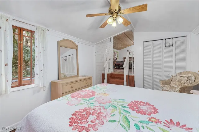 a bedroom with a bed a chandelier and dresser