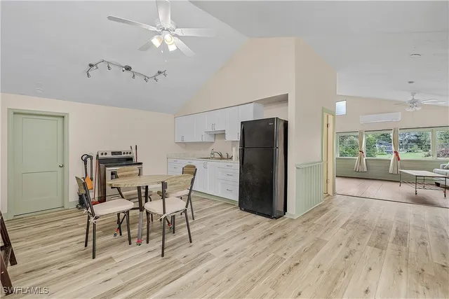 a view of a kitchen with refrigerator and wooden floor