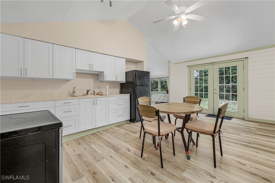 13841-13845 Robert Road Bokeelia, FL 33922 - Photo 45 of 50 a kitchen with stainless steel appliances granite countertop a stove top oven a sink dishwasher a dining table and chairs with wooden floor