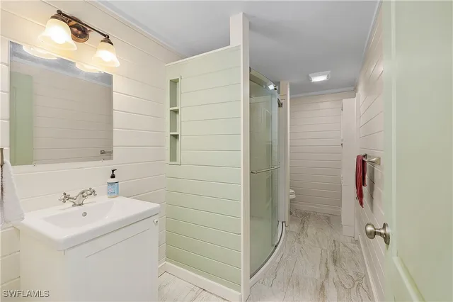 a bathroom with a sink mirror and shower