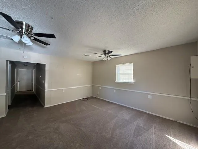 an empty room with a ceiling fan and a window