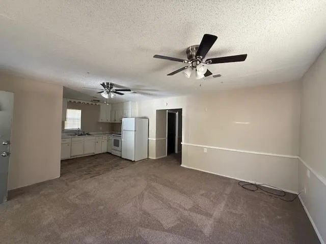 a view of a livingroom with a ceiling fan and window