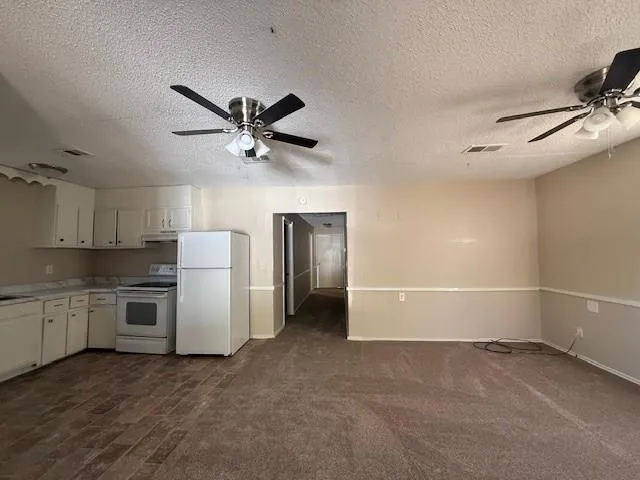 a view of a kitchen with a sink and a refrigerator