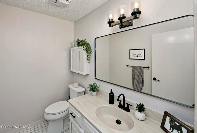 a bathroom with a sink mirror and toilet